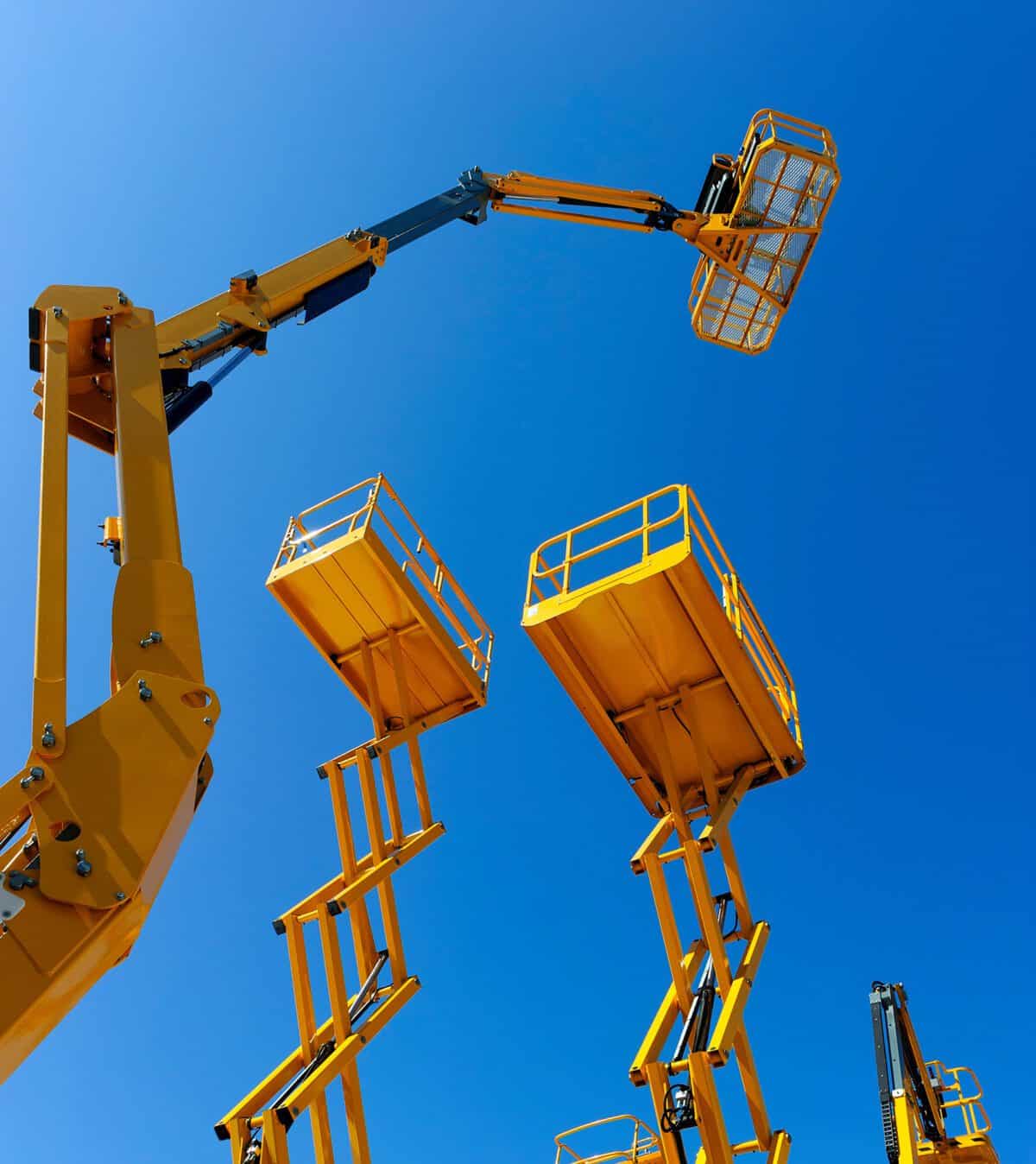 Viele gelbe Arbeitsbühnen, die hoch in den Himmel ragen.